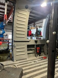 A truck is parked in the garage with its doors open.